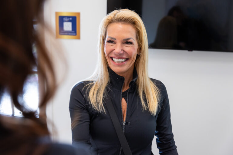 A woman is walking into the Frisco Body Contouring office for her treatment for Ultra hair restoration in Frisco, TX.